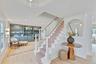 Stairs featuring plenty of natural light, ornamental molding, wood finished floors, and built in shelves