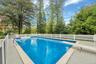View of swimming pool with a diving board, a fenced backyard, and a patio area