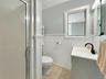 Bathroom featuring wainscoting, vanity, a shower stall, light tile patterned floors, and crown molding