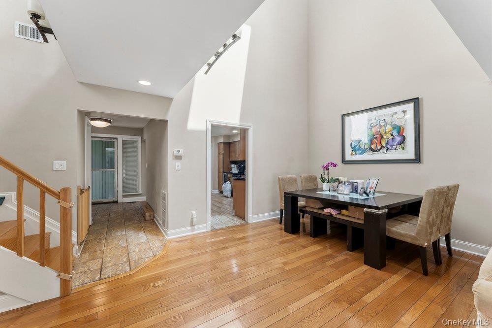 Hardwood flooring extending through the primary living area, complemented by a soaring vaulted ceiling