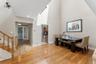 Hardwood flooring extending through the primary living area, complemented by a soaring vaulted ceiling