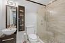 Bathroom featuring tile walls, a shower stall, and vanity
