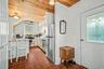 Kitchen featuring a wood-finish ceiling, stainless steel appliances, white cabinetry, and terracotta tile flooring