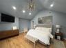 Bedroom with an inviting chandelier, vaulted ceiling, and light hardwood / wood-style floors