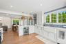 Kitchen featuring pendant lighting, white cabinets, wine cooler, a peninsula, and crown molding