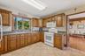 Kitchen with white appliances, brown cabinets, and light tile patterned floors