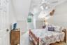 Large oversized guest room with window seat that has storage and walk in closet with vaulted ceilings.