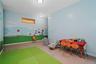 Room featuring light blue walls with a painted landscape mural, a single horizontal transom window, and flush-mount ceiling lighting