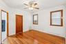 Unfurnished bedroom with radiator, light wood finished floors, cooling unit, and a ceiling fan