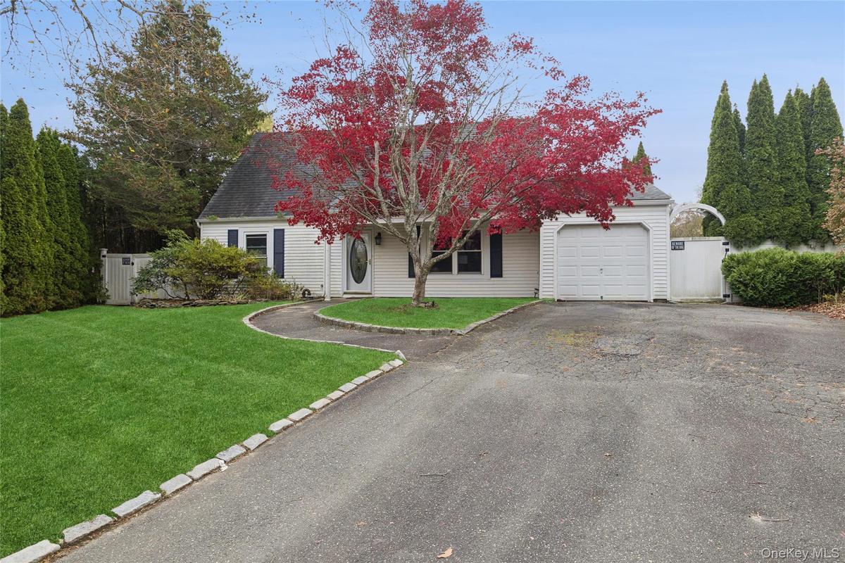 View of front of home featuring asphalt driveway, roof with shingles, and a garage
