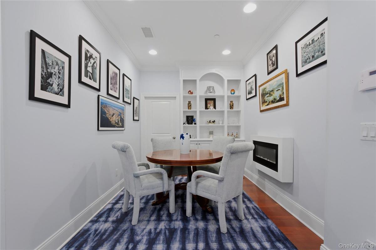 Versatile Den or Home Office with custom built-in shelving, currently utilized as a dining room