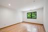Hardwood flooring, recessed lighting, and a large window with a dark frame