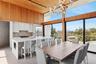 Dining space featuring rail lighting, a wealth of natural light, a towering ceiling, and a notable chandelier