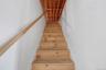 Staircase into attic with large storage area.