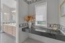 Recessed vanity area featuring a black countertop and a window with blinds