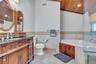Full bath featuring vanity, a bath, tile walls, a wainscoted wall, and wooden ceiling
