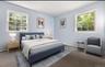 Carpeted bedroom featuring multiple windows
