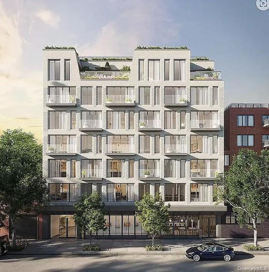 Contemporary multi-story building featuring a light-colored facade with numerous windows and private balconies