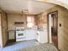 Kitchen space featuring patterned linoleum flooring and wood-look wall paneling