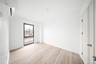 Unfurnished bedroom featuring light wood finished floors and a wall mounted air conditioner