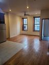 Unfurnished living room with hardwood / wood-style floors, a ceiling fan, baseboard heating, and recessed lighting