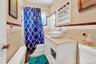 Bathroom featuring tile walls, vanity, wainscoting, and shower / bathtub combination with curtain
