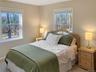 Carpeted bedroom featuring multiple windows