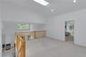 Open loft space featuring a skylight, recessed lighting, wood railing, and carpeted flooring overlooking lower level.