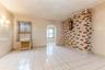 Spare room with light tile patterned floors, radiator heating unit, arched walkways, and crown molding