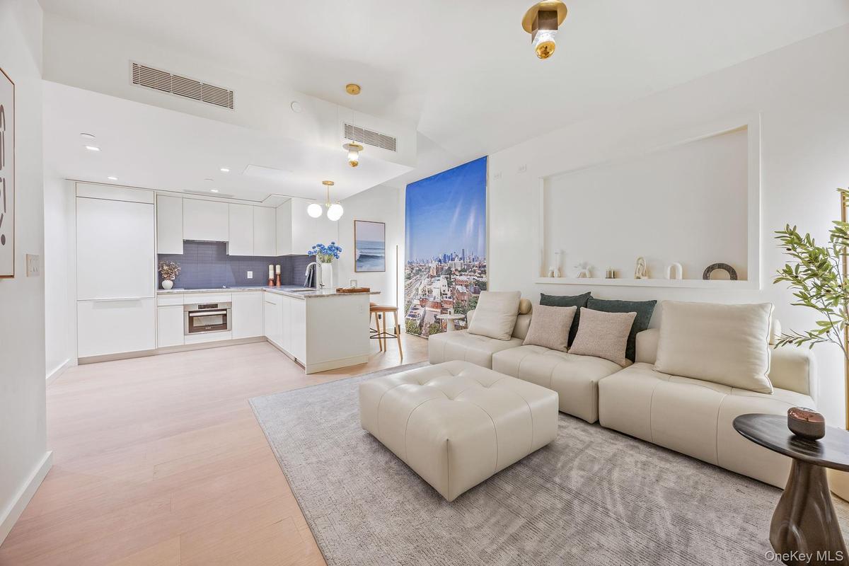 Living area with light wood finished floors and recessed lighting