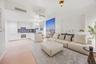 Living area with light wood finished floors and recessed lighting