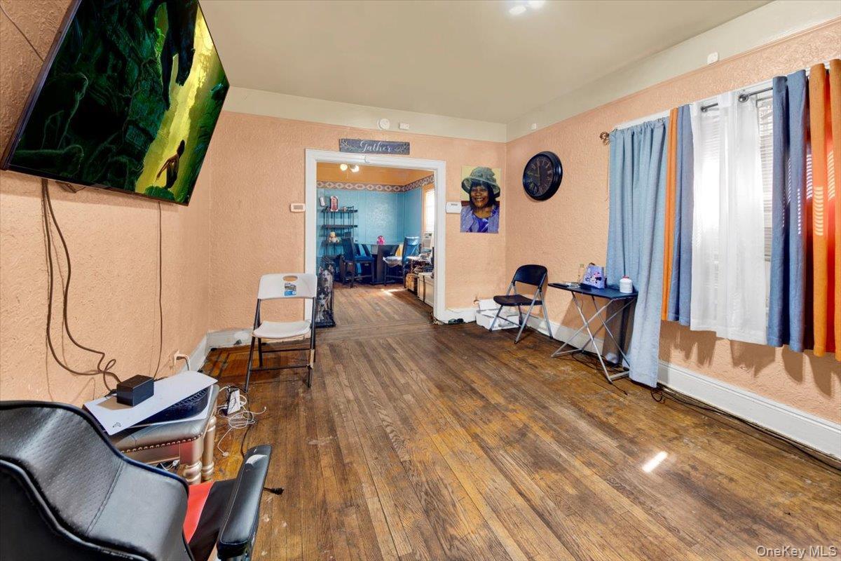Home office with a textured wall and dark wood-style flooring