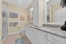 Bathroom featuring double vanity, a shower stall, recessed lighting, and light tile patterned flooring