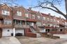 Townhome / multi-family property with brick siding, a garage, a chimney, concrete driveway, and stairway