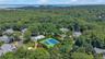 Aerial perspective showcasing a residential community nestled within lush tree-lined surroundings