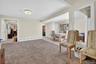 Living area featuring light tile patterned floors, light carpet, and a baseboard heating unit
