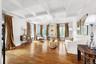 Coffered ceiling with a crystal chandelier, wood-finish flooring, and multiple windows
