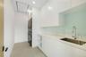 Laundry area featuring stacked washer / dryer, attic access, light tile patterned floors, and recessed lighting