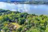 Aerial view of property's location featuring a heavily wooded area and a large body of water