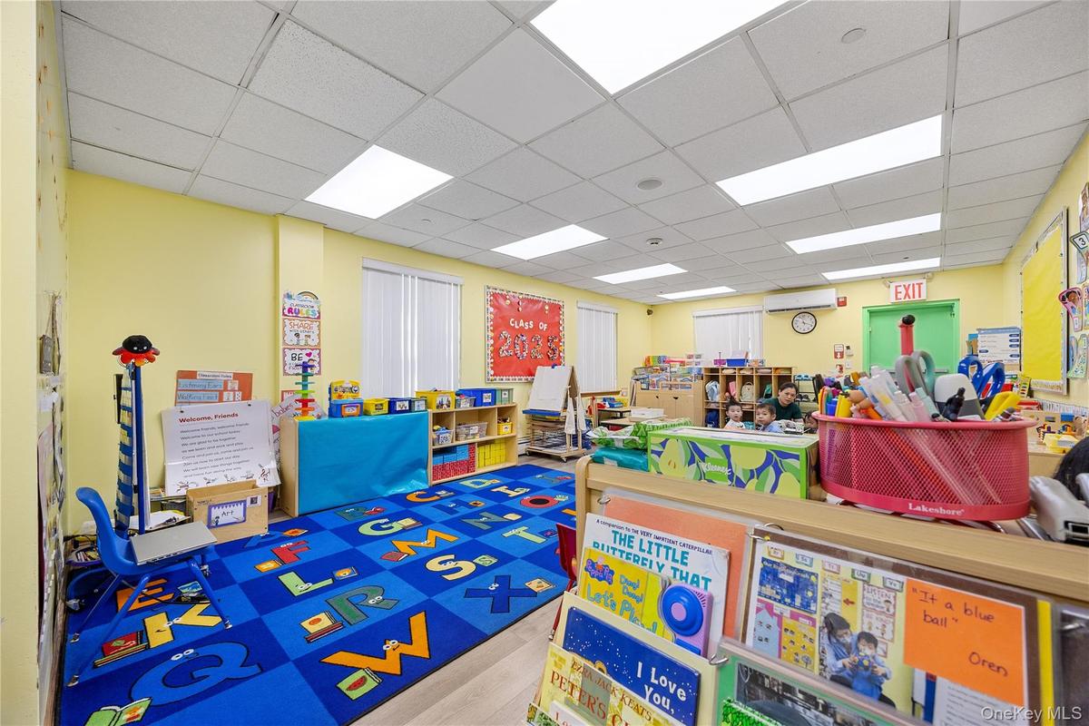 Playroom with a drop ceiling and wood finished floors