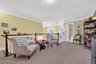 Living area with ornamental molding, light colored carpet, and an upstairs landing
