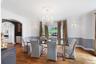 Hardwood flooring, arched doorway, built-in kitchen cabinetry, decorative ceiling medallion, and wall sconces
