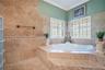 Primary Bathroom with dual granite vanities, Spacious Walk-In Shower with 7 heads and detachable hose and a large, separate tub