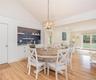 Dining space featuring vaulted ceiling, a chandelier, light wood finished floors, and recessed lighting