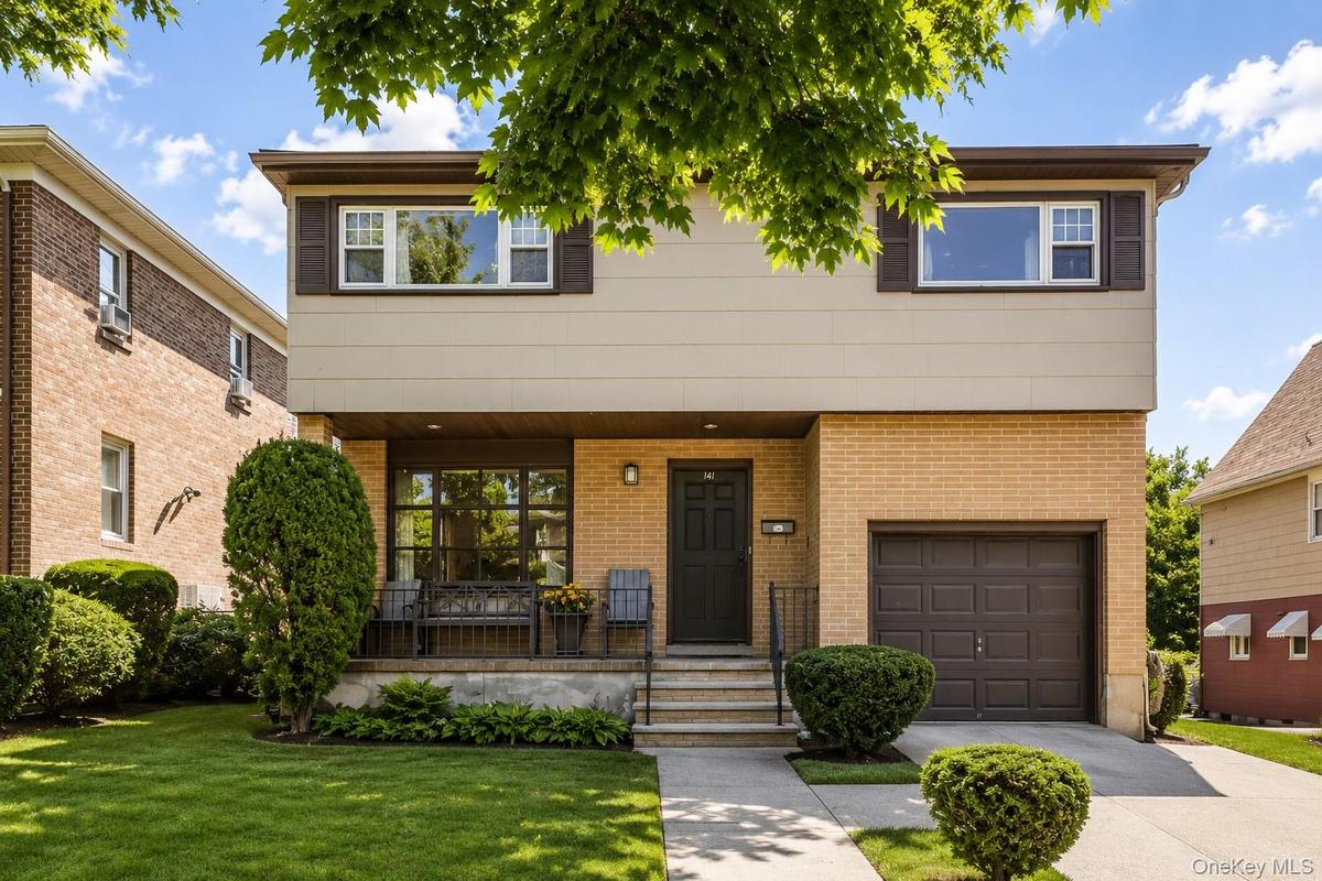 Split-level residence featuring a brick and siding facade, an attached single-car garage, and a concrete driveway