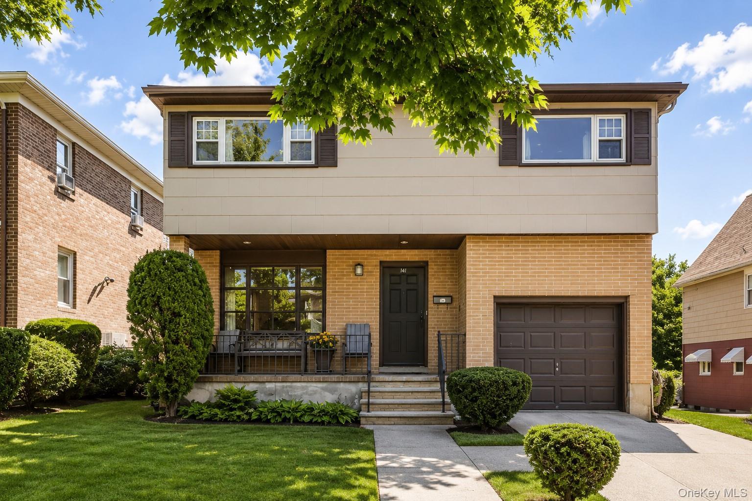 Split-level residence featuring a brick and siding facade, an attached single-car garage, and a concrete driveway