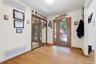 Entryway featuring wood-finish flooring, a double front door with decorative glass inserts, and a full-length mirrored closet
