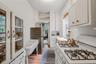 Kitchen with white cabinets, light countertops, freestanding refrigerator, light wood-style floors, and a textured ceiling