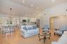 Living area with light wood finished floors, high vaulted ceiling, a chandelier, and recessed lighting