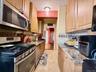 Well maintained kitchen, with light oak cabinets, granite countertop, tiled backsplash.